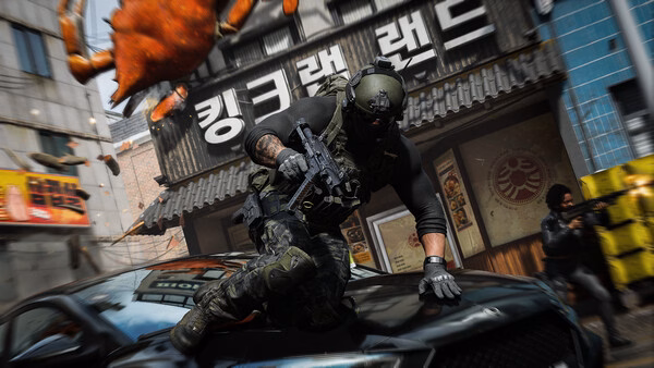 A Call of Duty®: Modern Warfare® 4 screenshot showing a soldier with a rifle sliding over a car in an urban combat zone.
